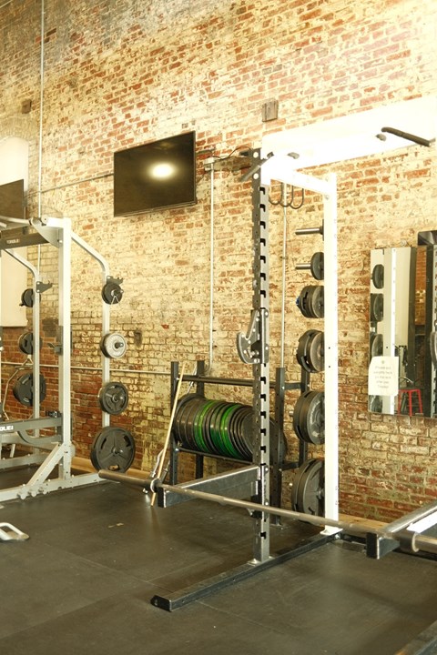 a gym with weights and a television in it
