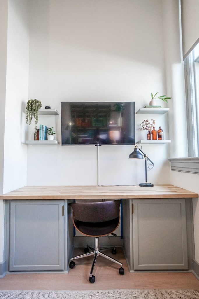 built-in desk and wall mounted TV in apartment at Myers Medical Lofts