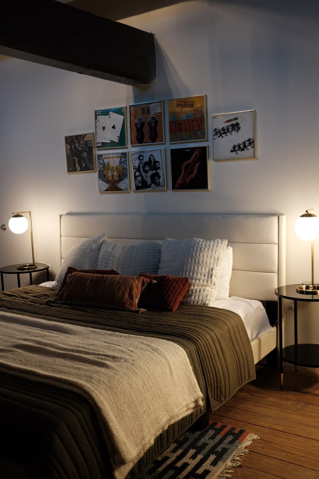 a bedroom with a bed and pictures on the wall