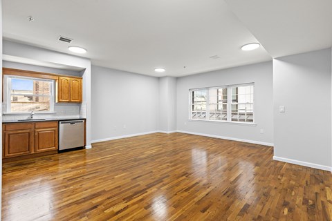 A large empty room with wooden floors and white walls.