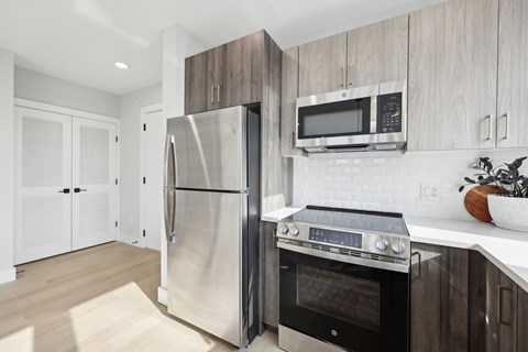 A modern kitchen with a stainless steel refrigerator and oven.