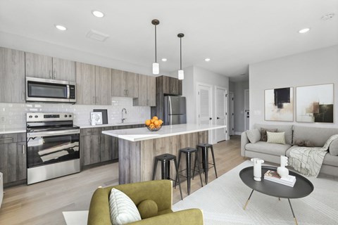 A modern kitchen with a green armchair and a dining table.