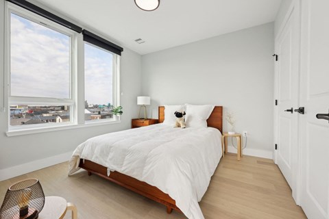 A bedroom with a large bed and a view of the city.