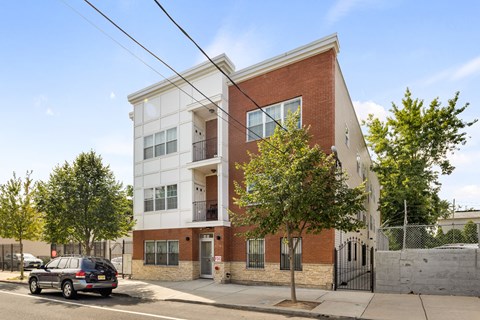 A modern two-story apartment building with a brick facade and a white trim.