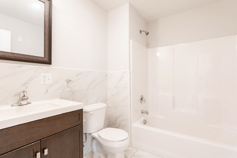 a white bathroom with a sink toilet and shower