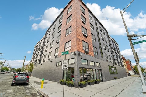 A street view of a building with a car parked in front.