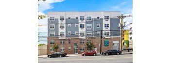 A multi-story building with a parking lot in front of it.