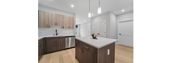 A modern kitchen with wooden cabinets and a white countertop.