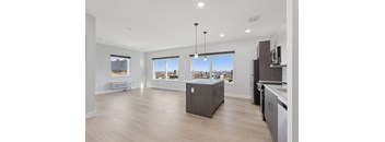 A spacious kitchen with a view of the cityscape outside the windows.