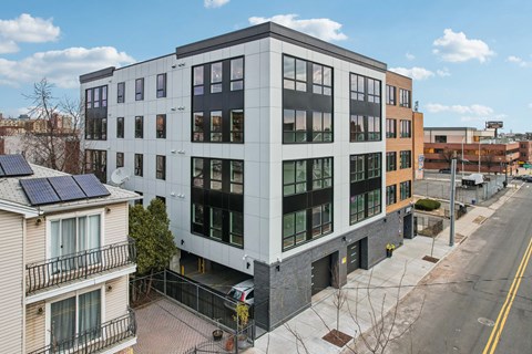 A modern building with a balcony and solar panels on the roof.