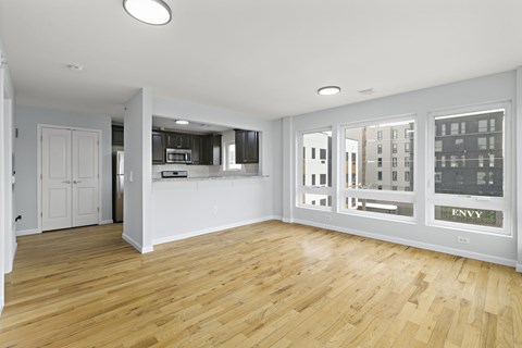 A spacious room with wooden floors and white walls.