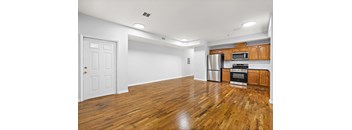 A kitchen with wooden floors and white walls.