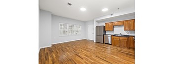A kitchen with wooden floors and white walls.