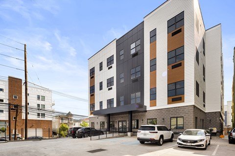 a tall apartment building with cars parked in front of it