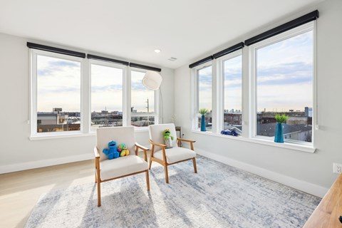 A living room with a white chair and a blue rug.