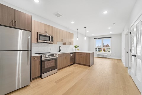 A modern kitchen with wooden cabinets and stainless steel appliances.