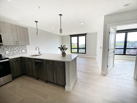a kitchen and living room with white walls and wood floors