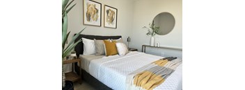 a bedroom with a white bedspread and yellow and white pillows