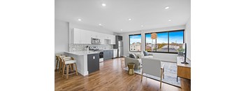A modern kitchen with a dining area and a view of the city.