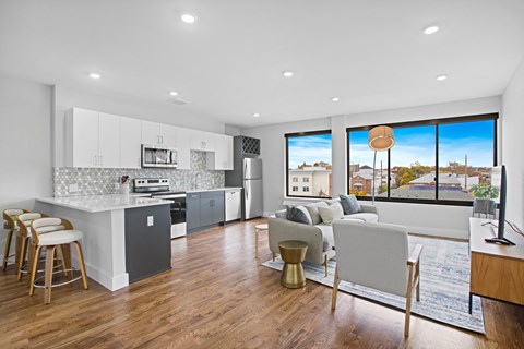 A modern kitchen with a dining area and a view of the city.