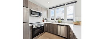 A modern kitchen with stainless steel appliances and wooden cabinets.