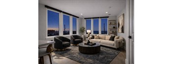 A living room with a large window overlooking the city at dusk.