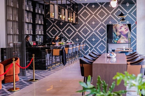 the bar area of a restaurant with tables and chairs