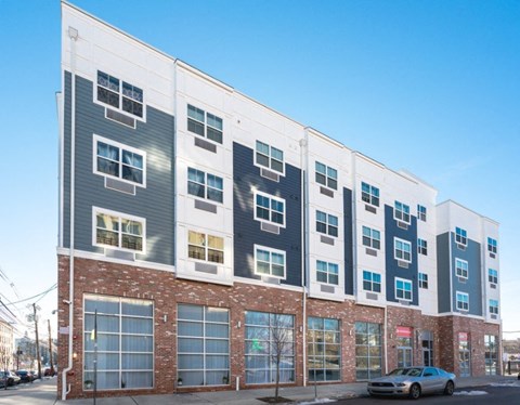 A modern multi-story building with a mix of brick and panel construction.