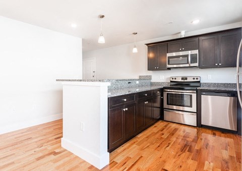 A kitchen with dark brown cabinets and stainless steel appliances.