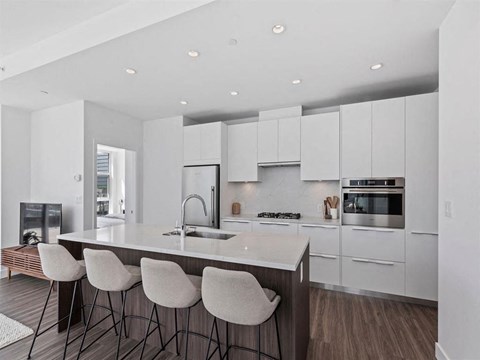 a kitchen with white cabinets and a marble counter top