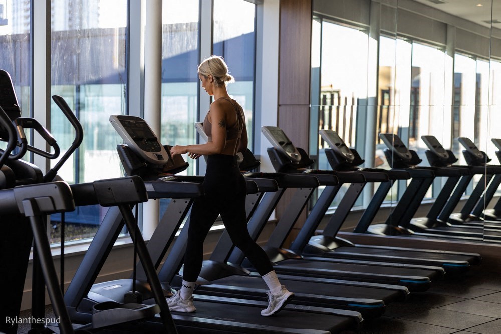 a woman running on a treadmill in a gym
