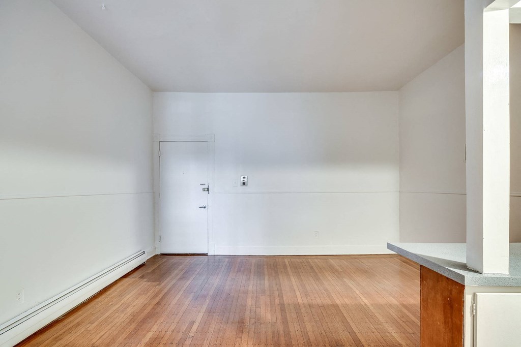 a living room with wood floors and white walls