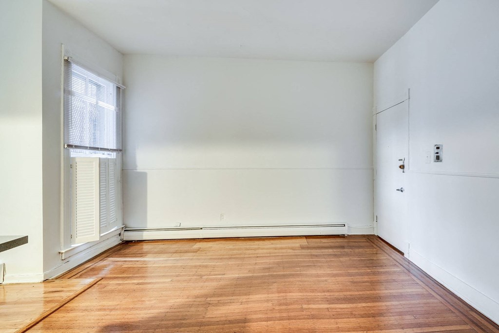 a living room with white walls and a wood floor