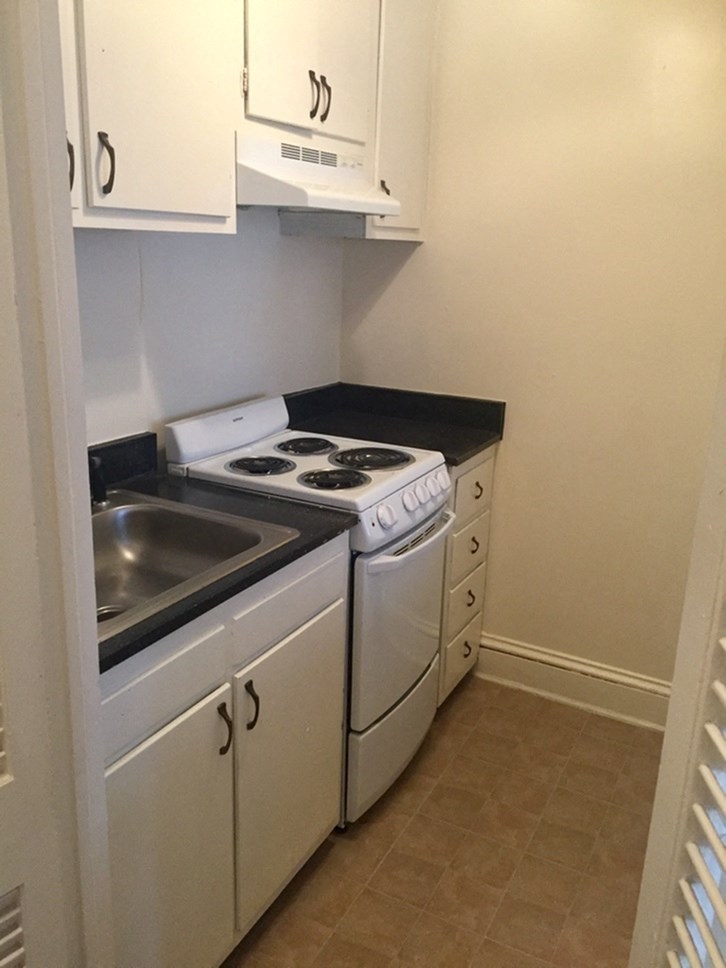 a kitchen with white appliances and white cabinets and a sink