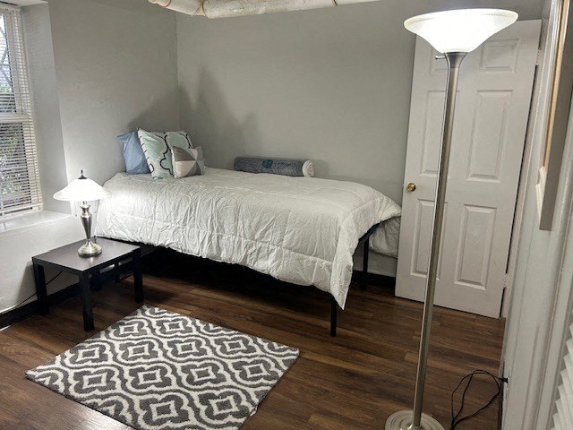 a small bedroom with a bed and a lamp