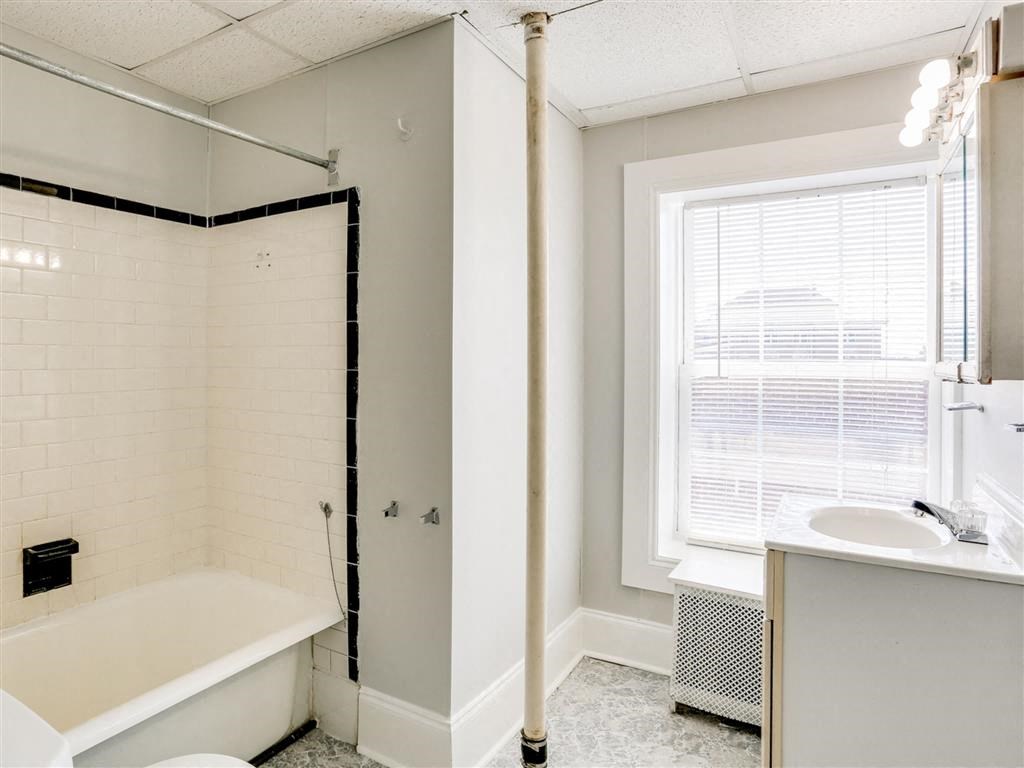 a bathroom with a tub and a sink and a window