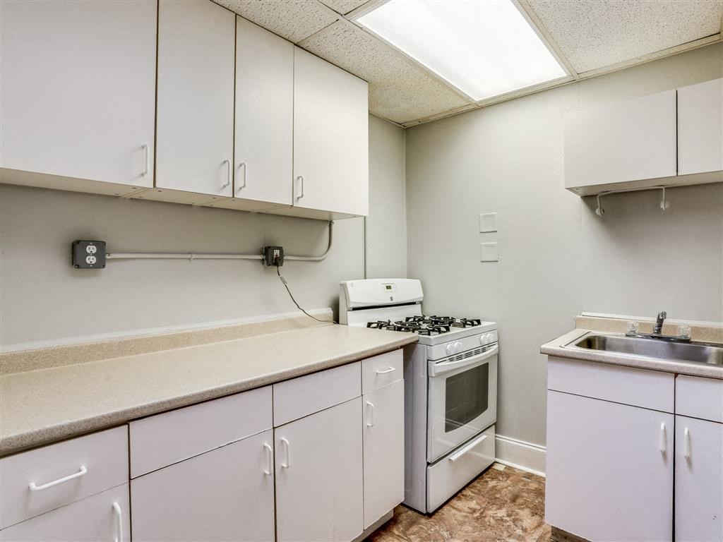 a kitchen with white cabinets and a stove and a sink