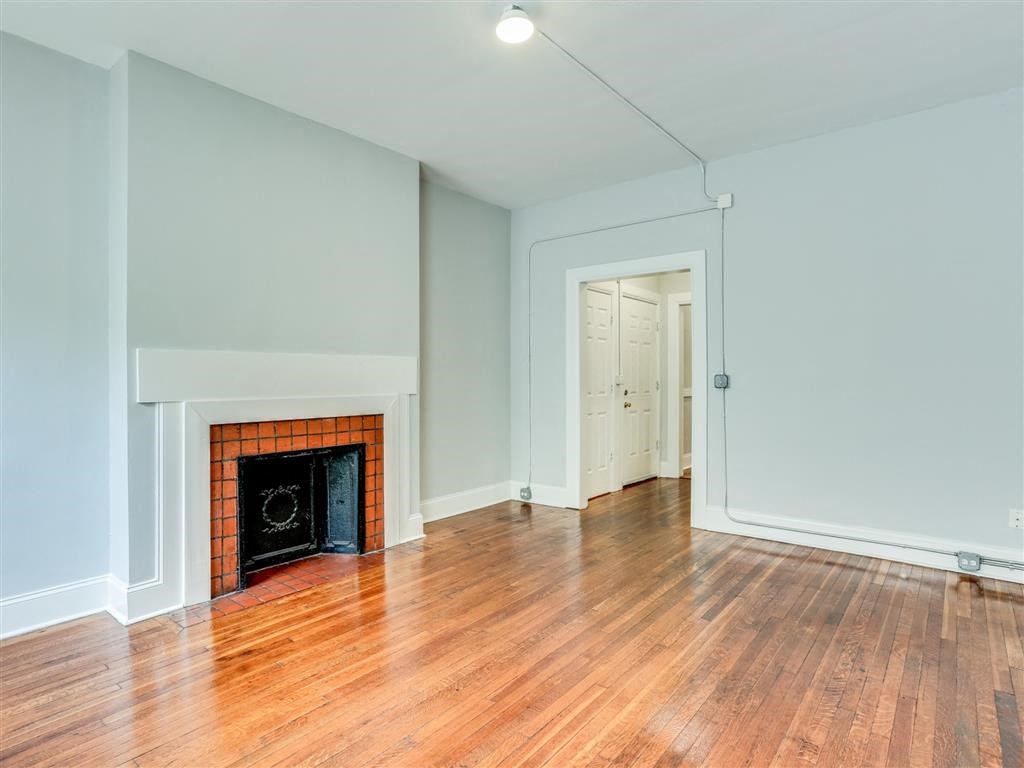 a living room with a fireplace and a wooden floor