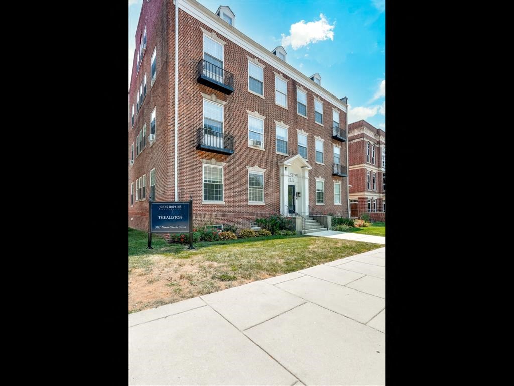 a brick building with a sidewalk in front of it