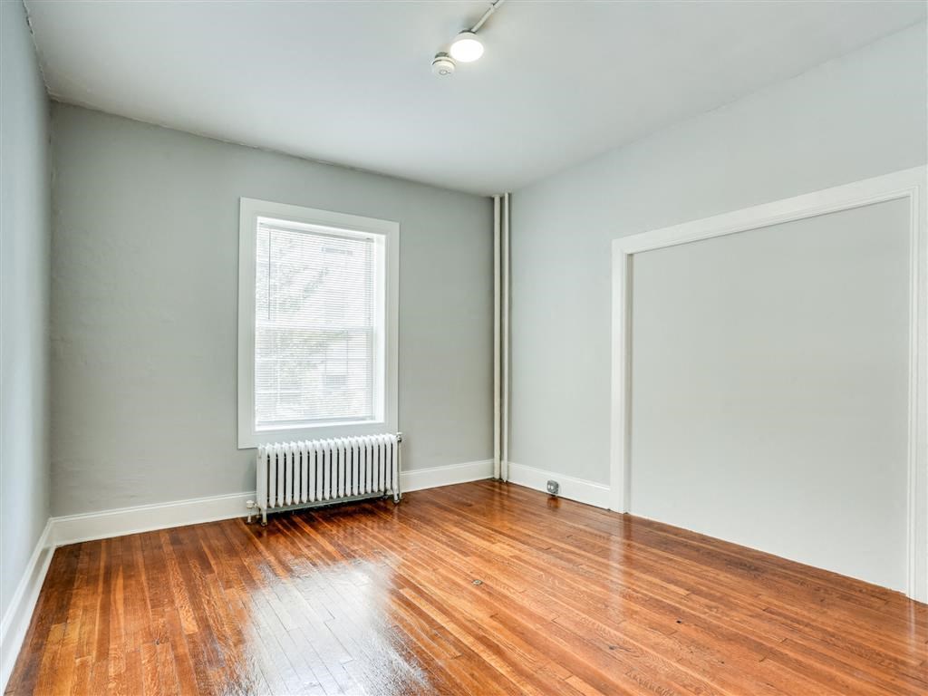 an empty room with wood floors and a window