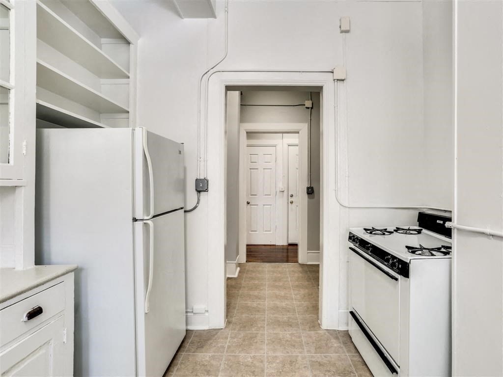 a kitchen with white cabinets and a white refrigerator