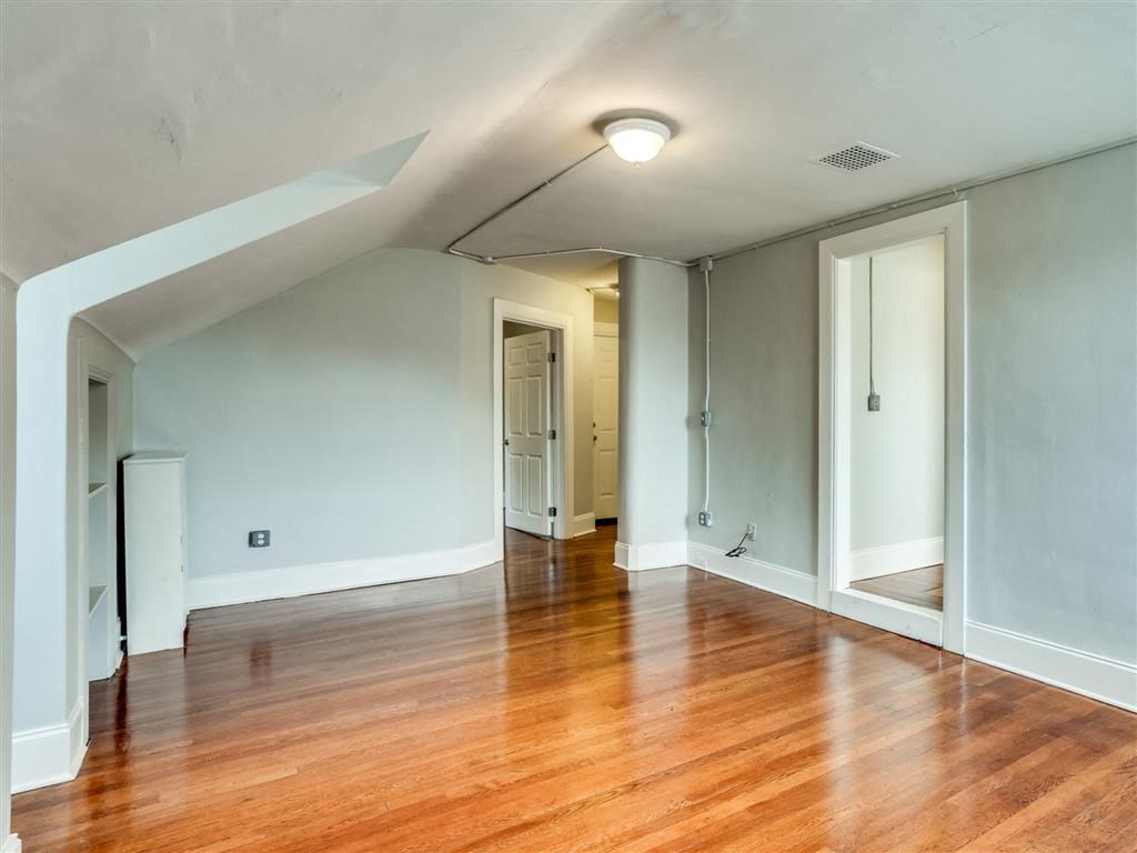 an empty living room with a hard wood floor
