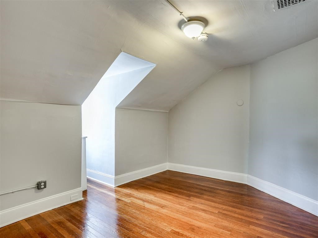 an empty room with a hard wood floor and white walls