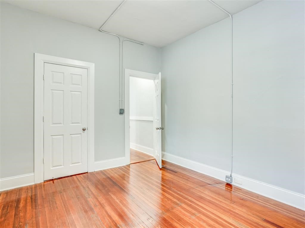an empty room with wood floors and a white door