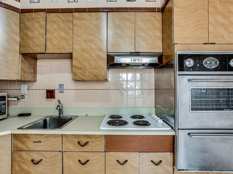 A kitchen with wooden cabinets and a stove top oven.