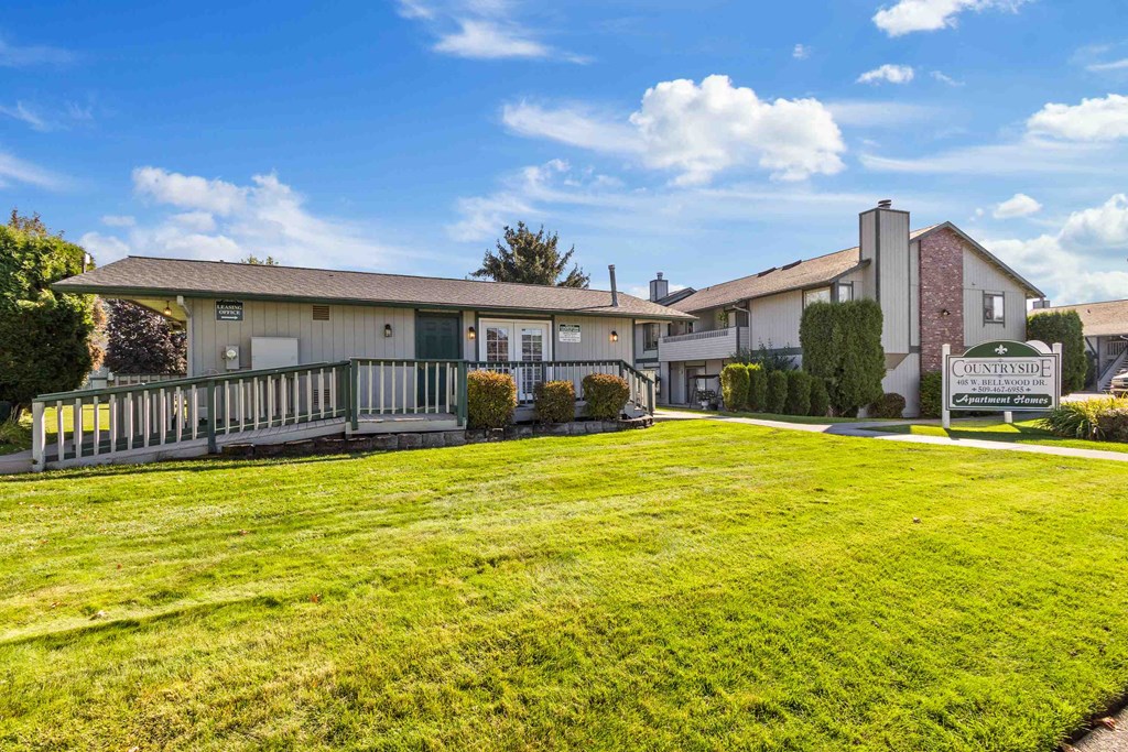 a yard with a house and a sign in front of it