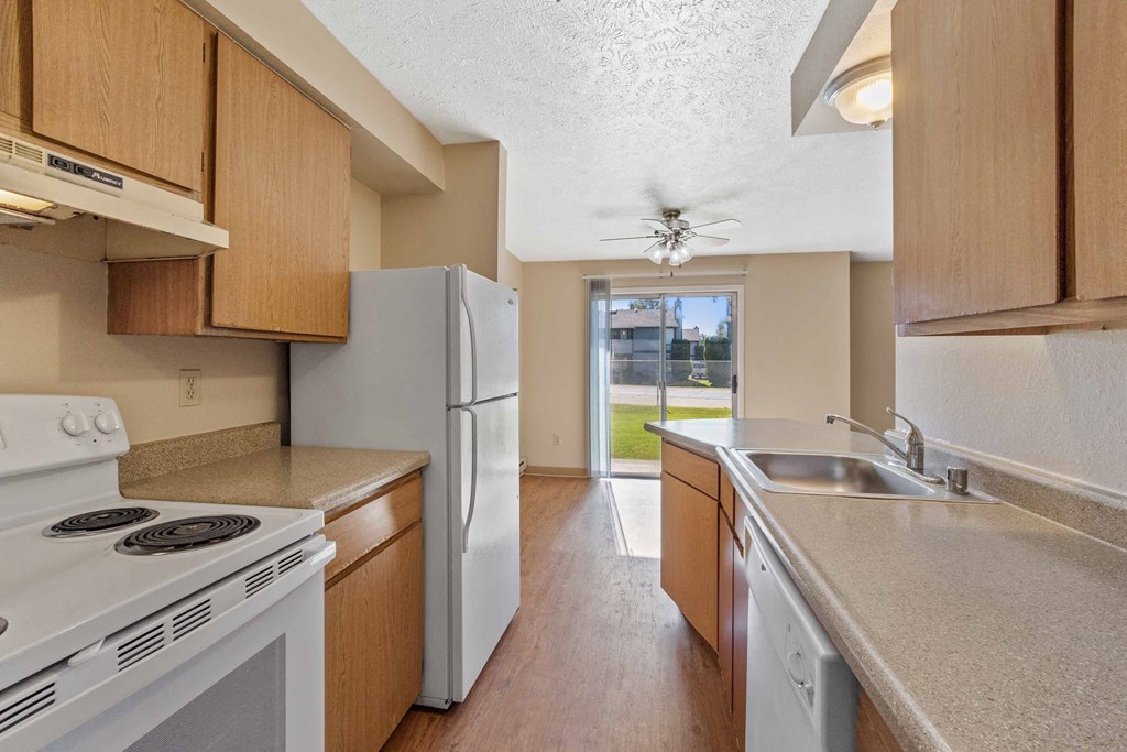 a kitchen with white appliances and wooden cabinets