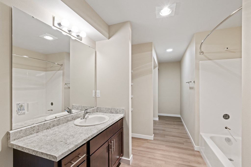 a bathroom with a large mirror and a sink and a shower