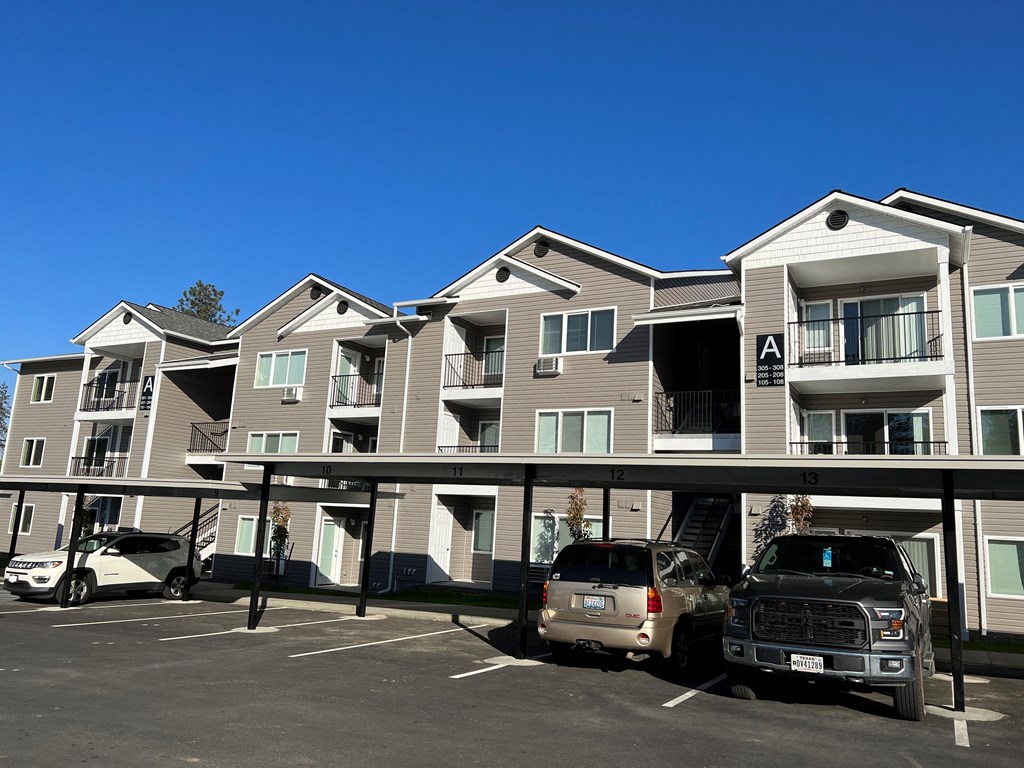an apartment building with cars parked in front of it
