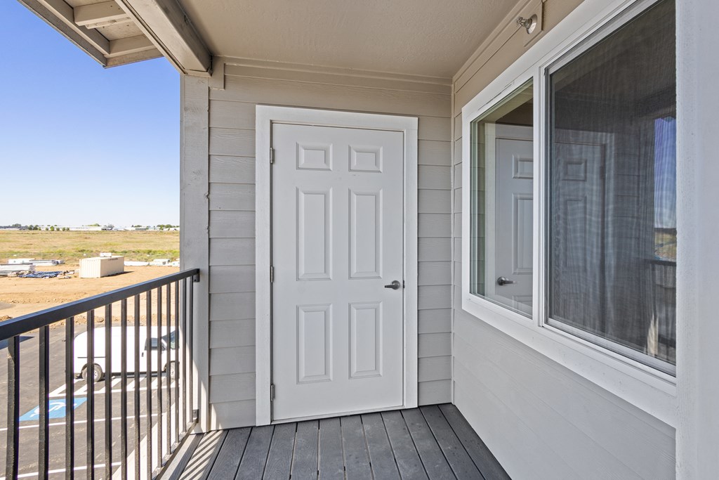 the view from the balcony of a home with a white door